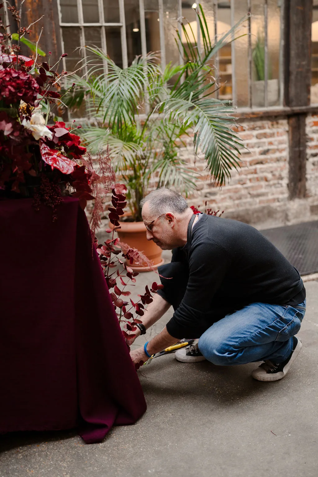 Le fleuriste installe l'arche de fleurs bordeaux