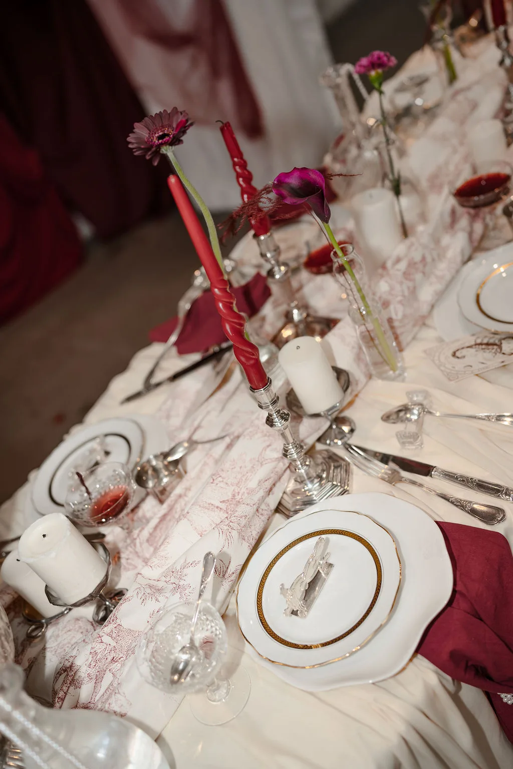 La table dressée, œillets et bougies bordeaux
