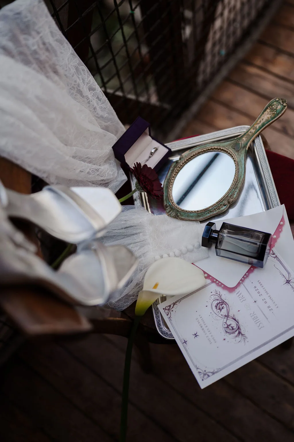Le faire-part, le miroir et le parfum posés sur la chaise