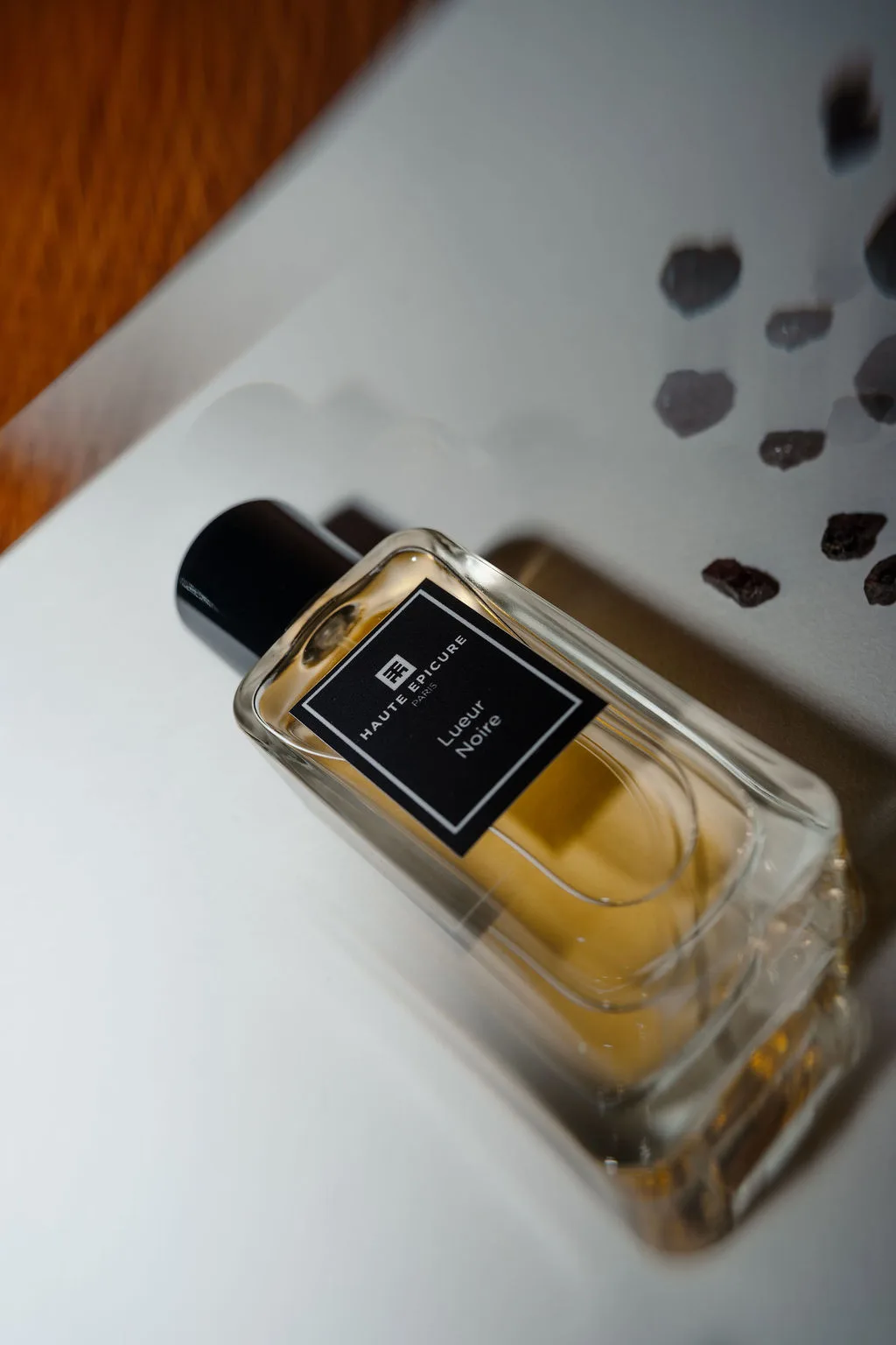 Un flacon de parfum posé sur une chemise blanche